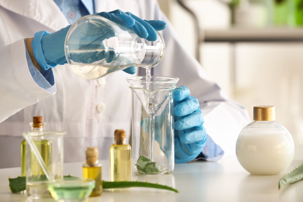 Cosmetic chemist mixing ingredients to find the perfect formulation using all natural ingredients.